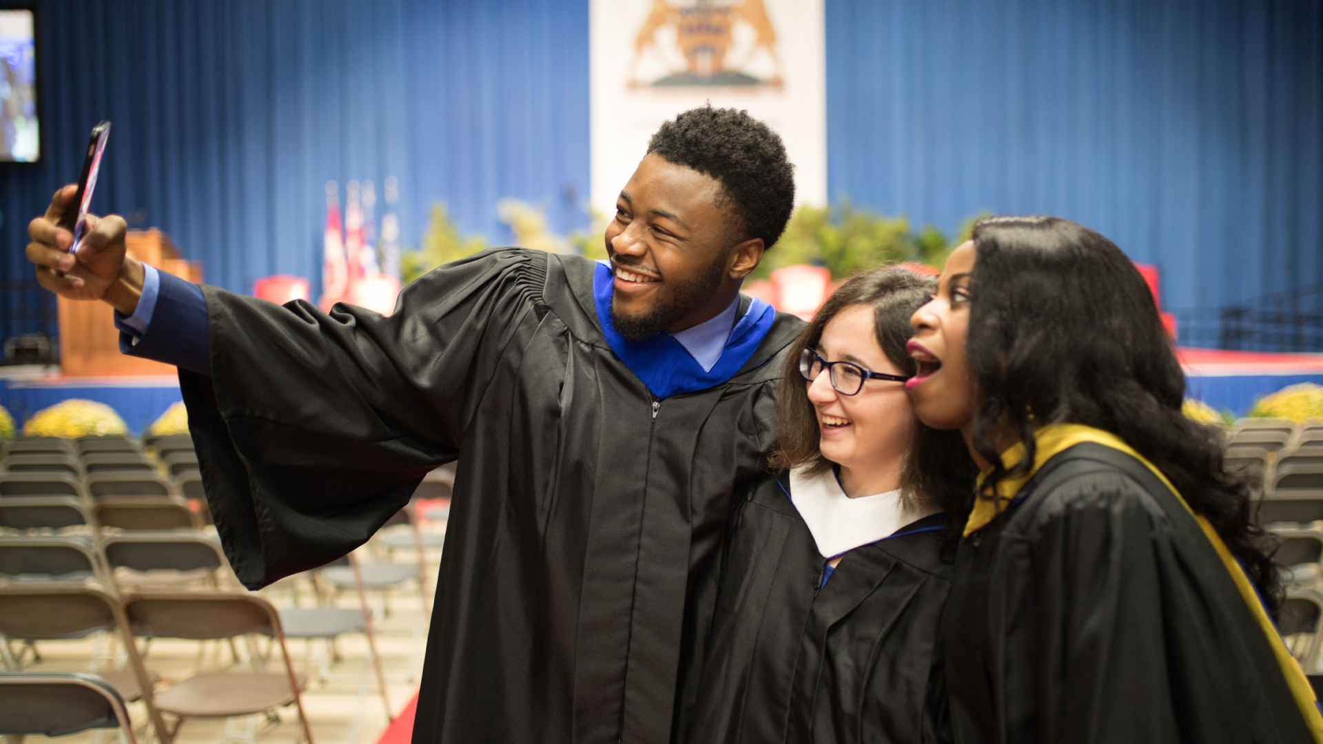 students in graduation gowns posing for photo